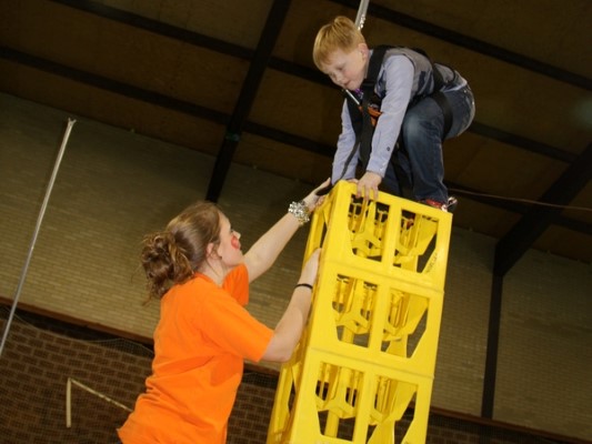 Een kinderfeestje voor de waaghalzen. Kratten stapelen. Wie durft het hoogst.